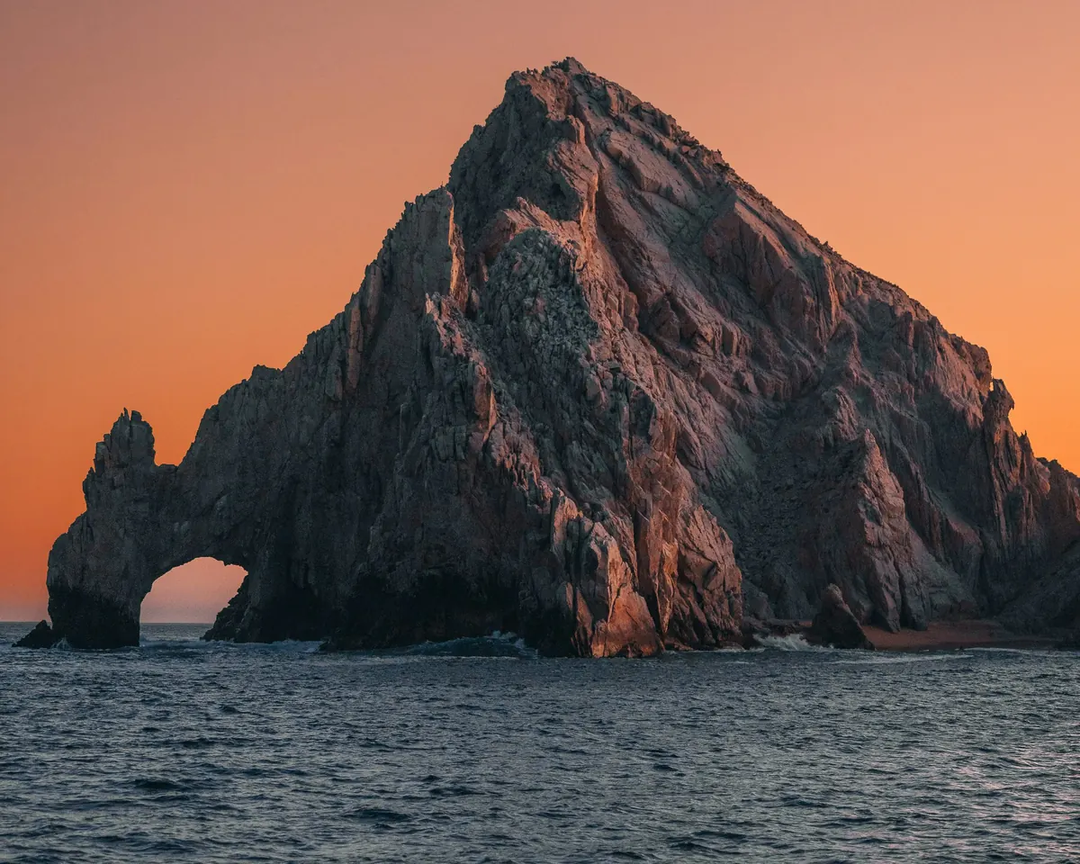 The rock arch at Land's End glowing at sunset