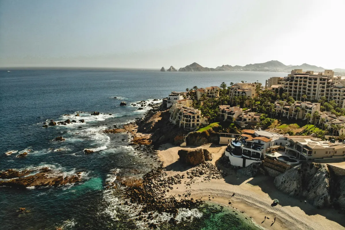 Rocky coastline and a hillside resort above the sea in Los Cabos