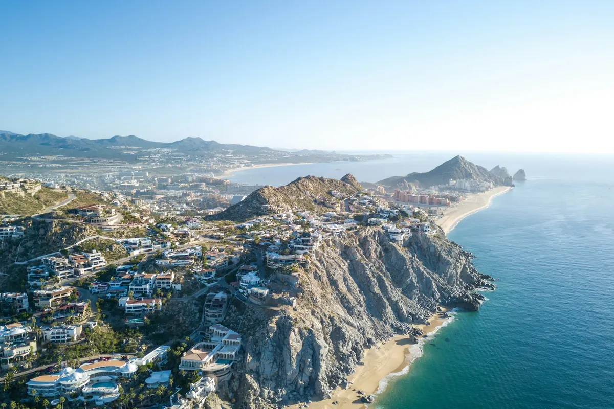 Hillside homes above a long Pacific beach near Cabo San Lucas